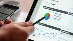 digital marketing concept hand holding phone while looking at marketing graph 1
