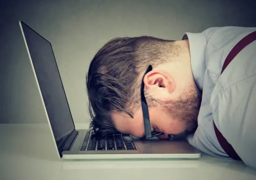 tired man with head on laptop