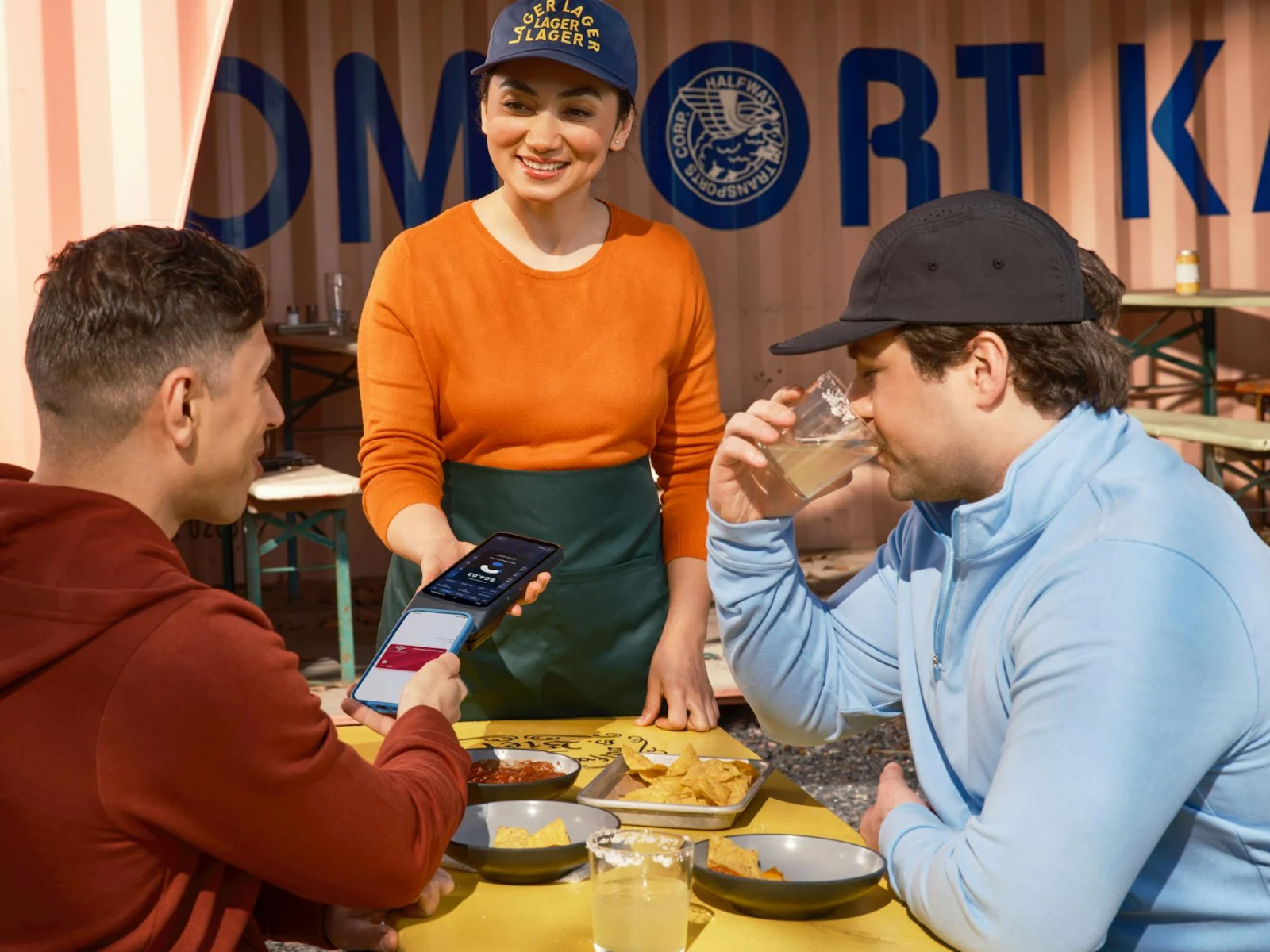 Two diners enjoying a meal with mobile phone and food at a casual restaurant table